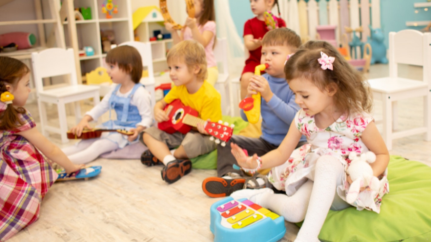 group of children and preschoolers playing in a colourful nursery room
