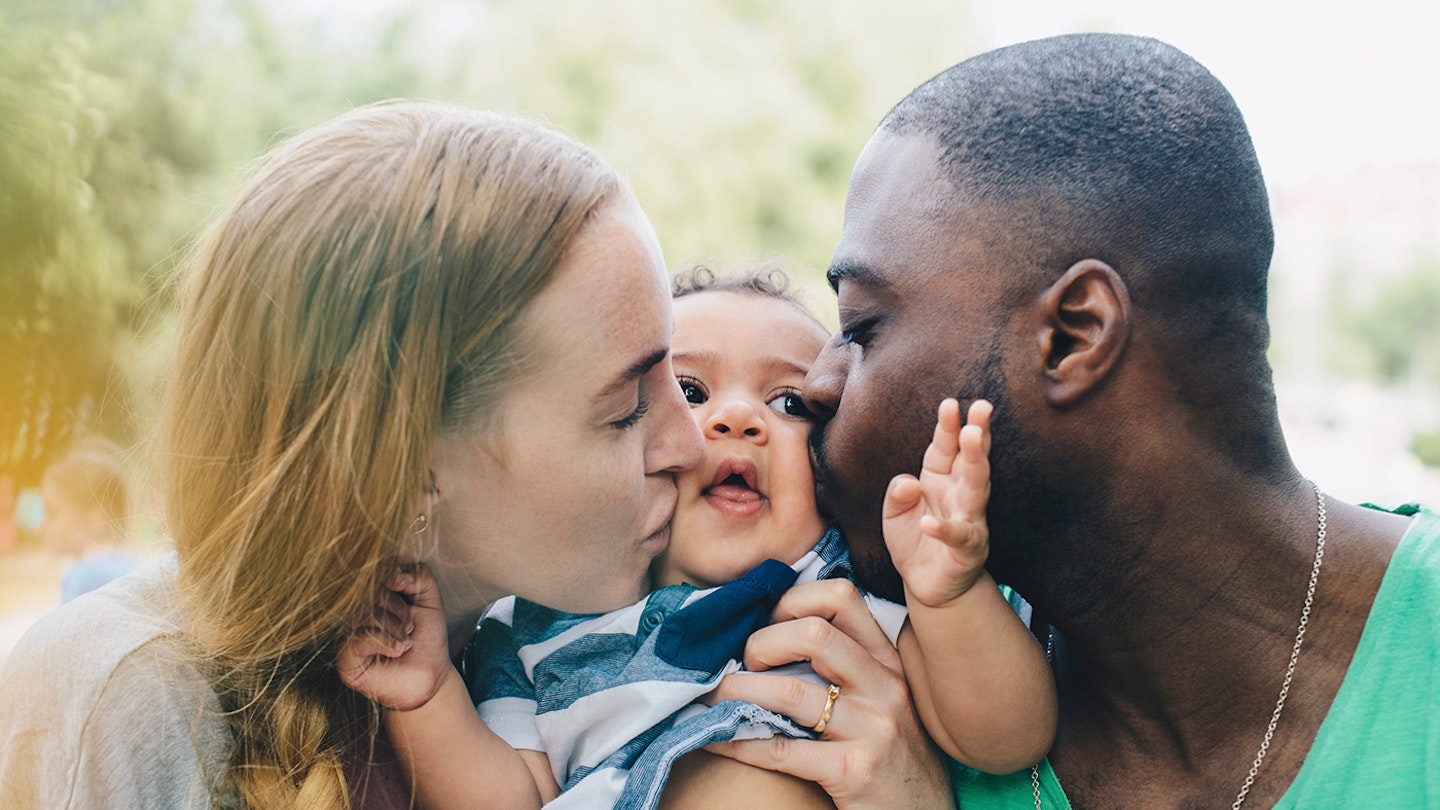 mum and dad giving baby boy cuddle and kiss