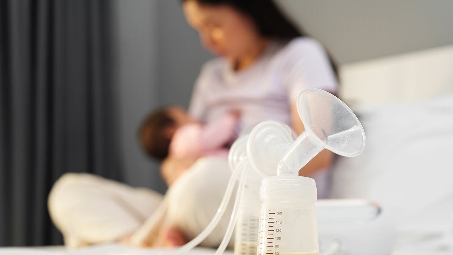 mum breastfeeding baby with electric breast pump in foreground
