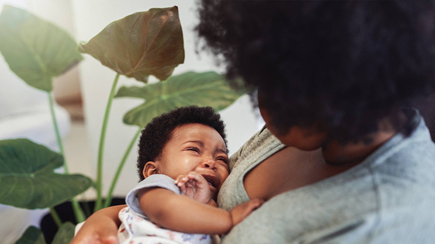 A mother comforting her baby by rocking and holding him as an alternative to gripe water