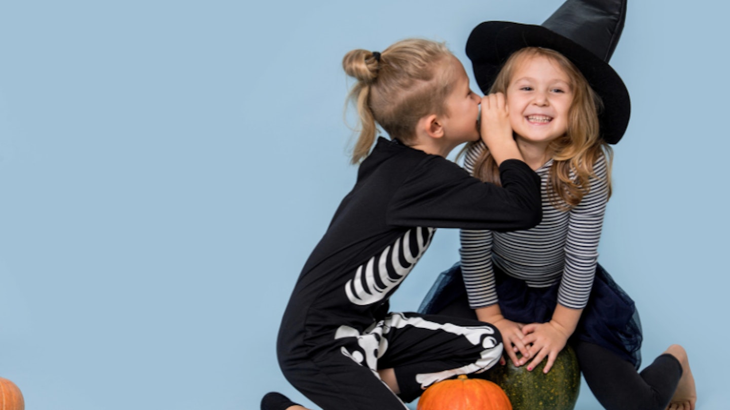 Children whispering Halloween jokes