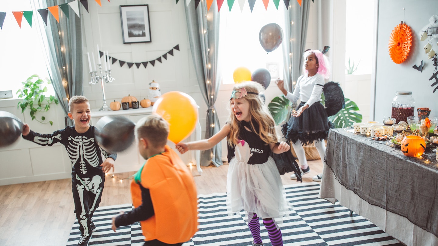 Children dancing around to the best halloween songs for kids at a party