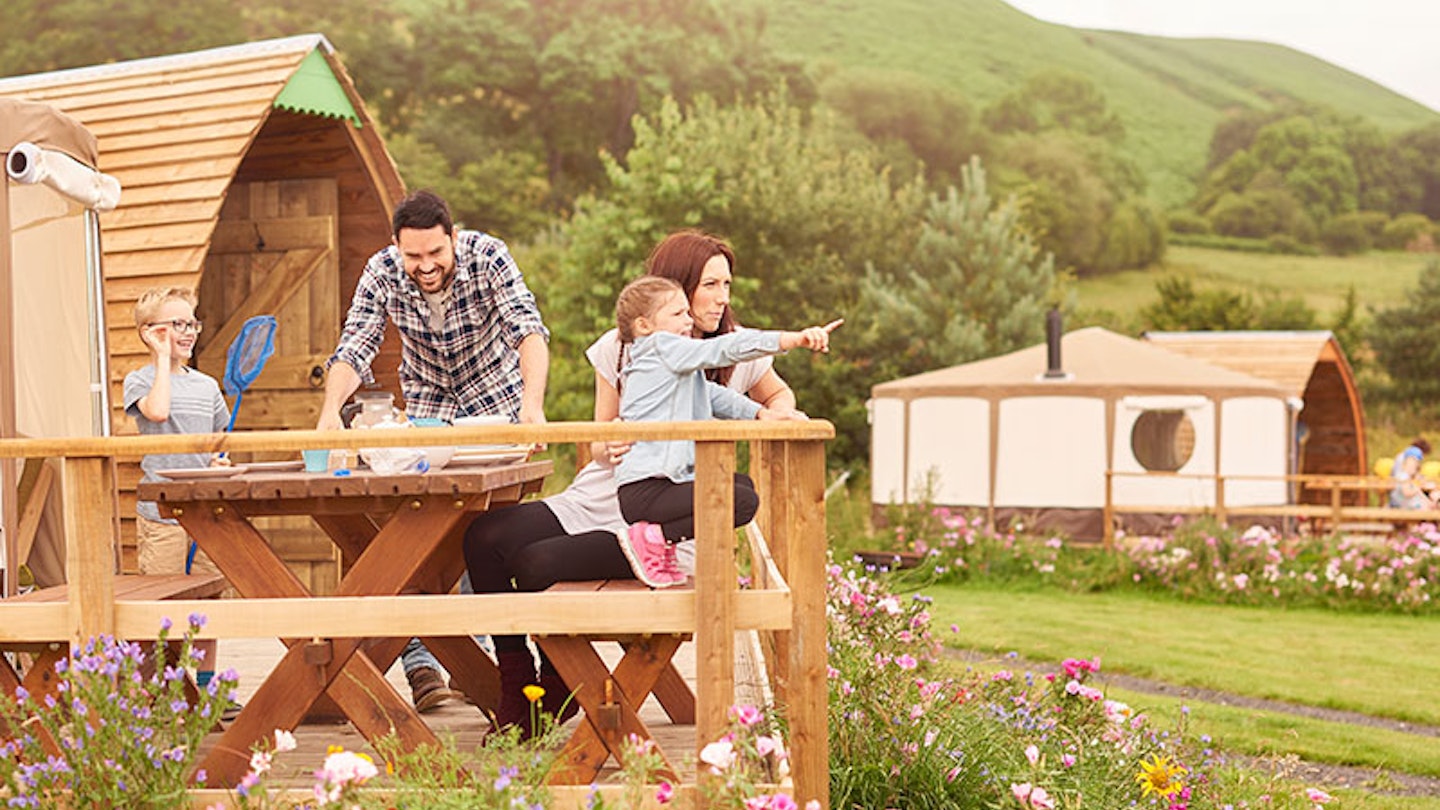A family on the decking of their holiday park accommodation
