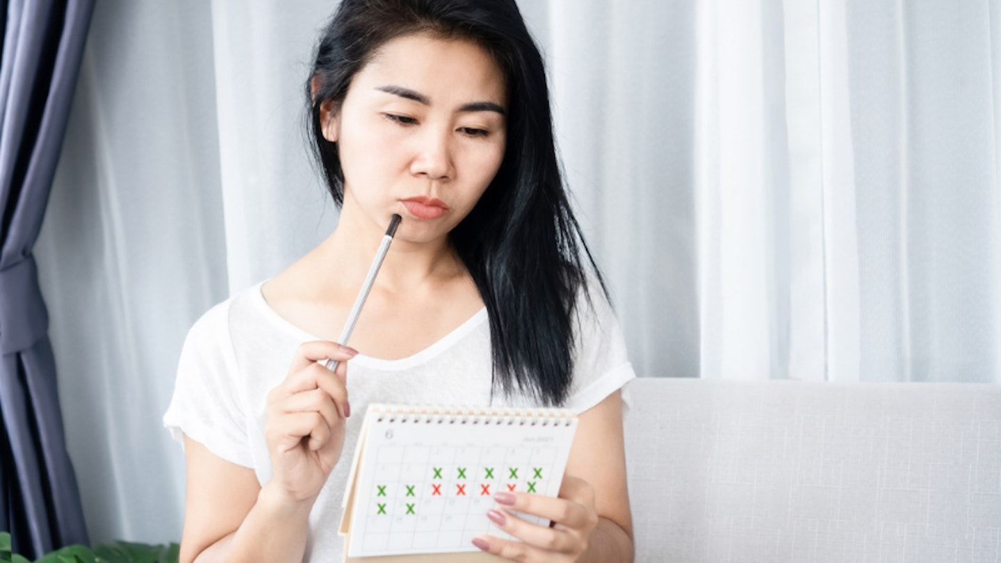 Woman checking calendar because of irregular periods
