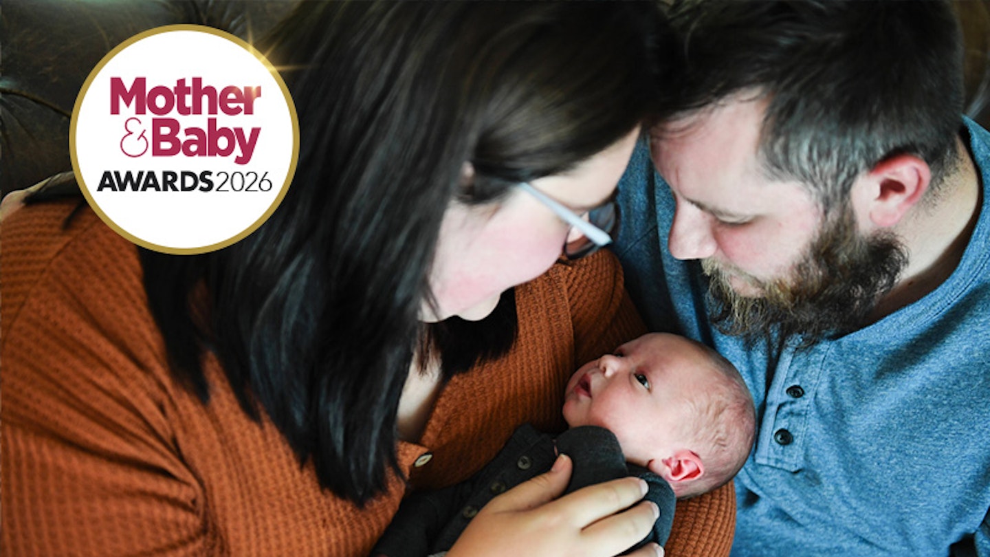 A mum and dad cuddling their baby - photo taken from a high angle