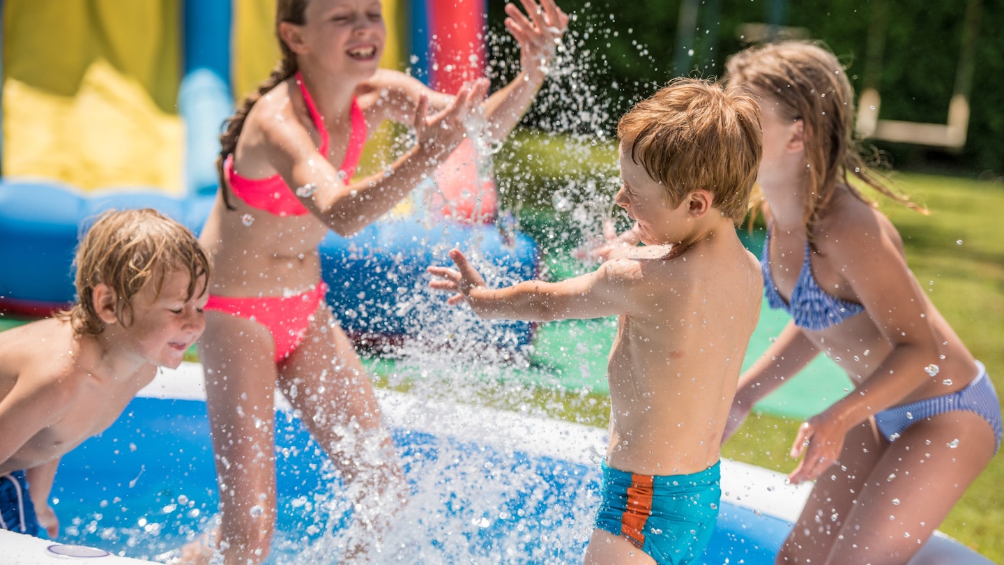 Children having fun in paddling pool⁠