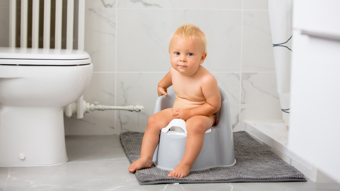 Baby boy sitting on potty