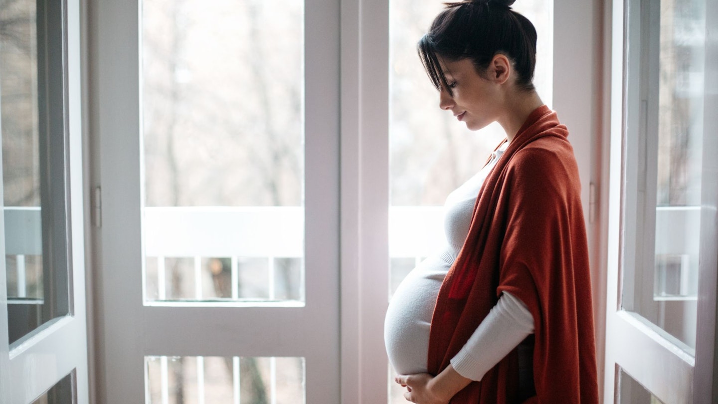 Pregnant Woman Standing on a Balcony