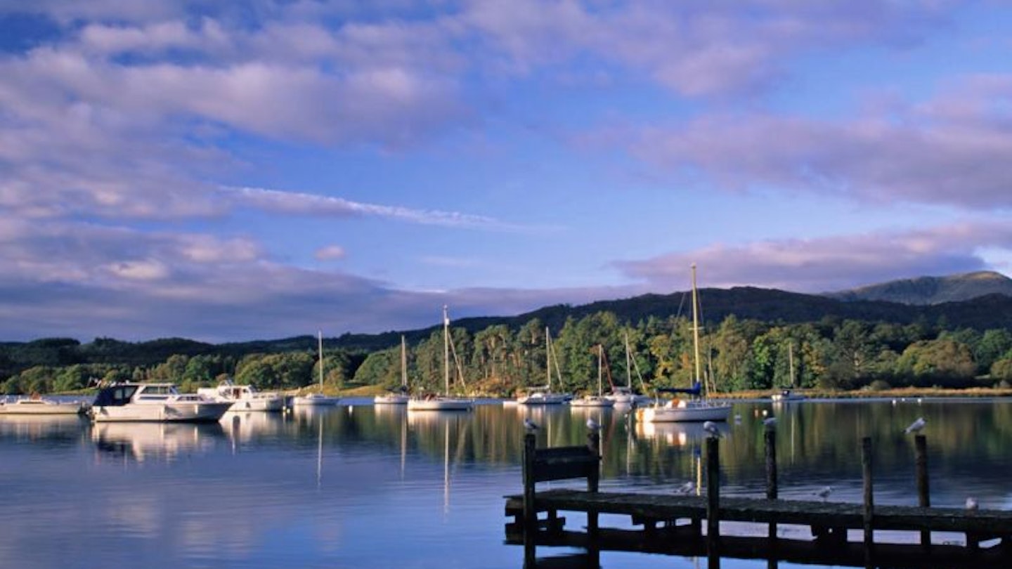 Boats on the lake at sunset with a jetty sticking out into the water