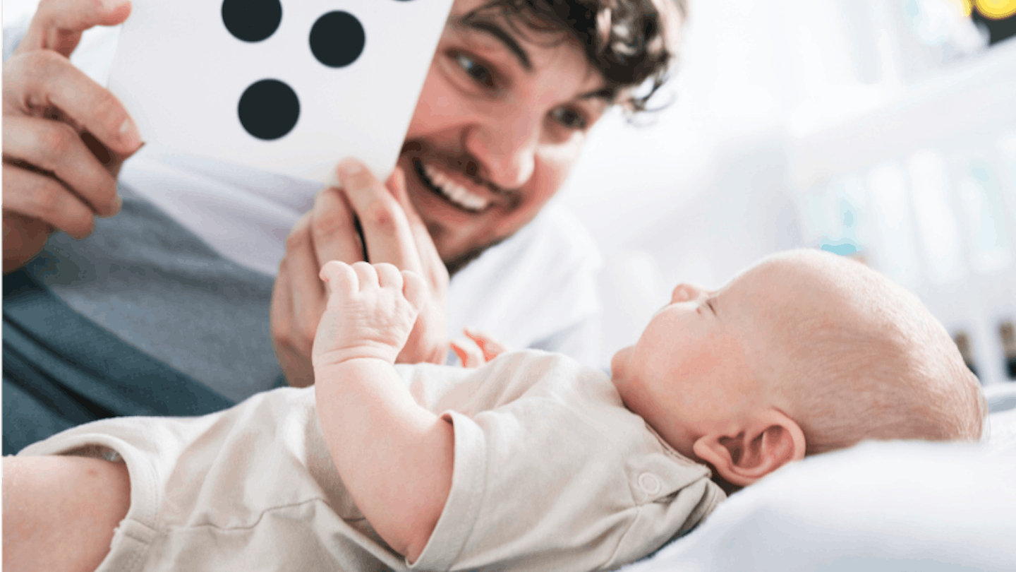 Dad showing baby black and white sensory flashcard